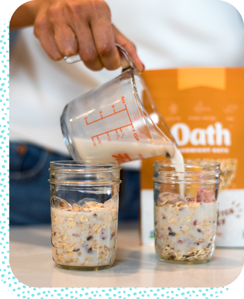 Milk being poured into mason jars of overnight oats - Oath Oats